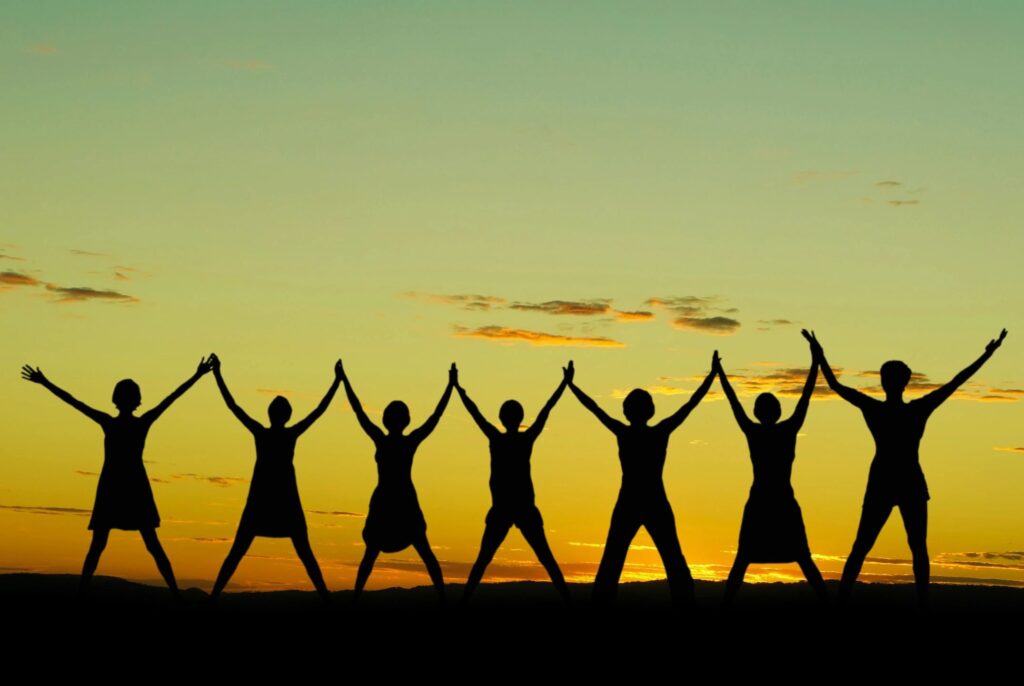 children standing up with hands in the air