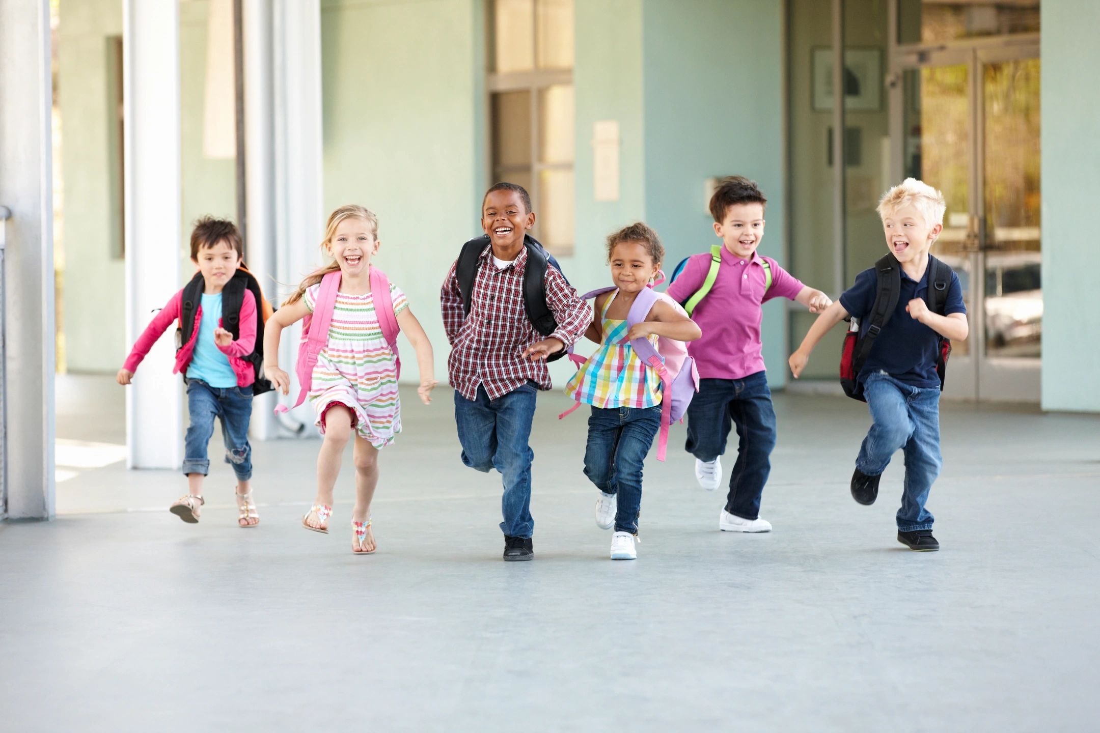 happy children running and carrying backpacks